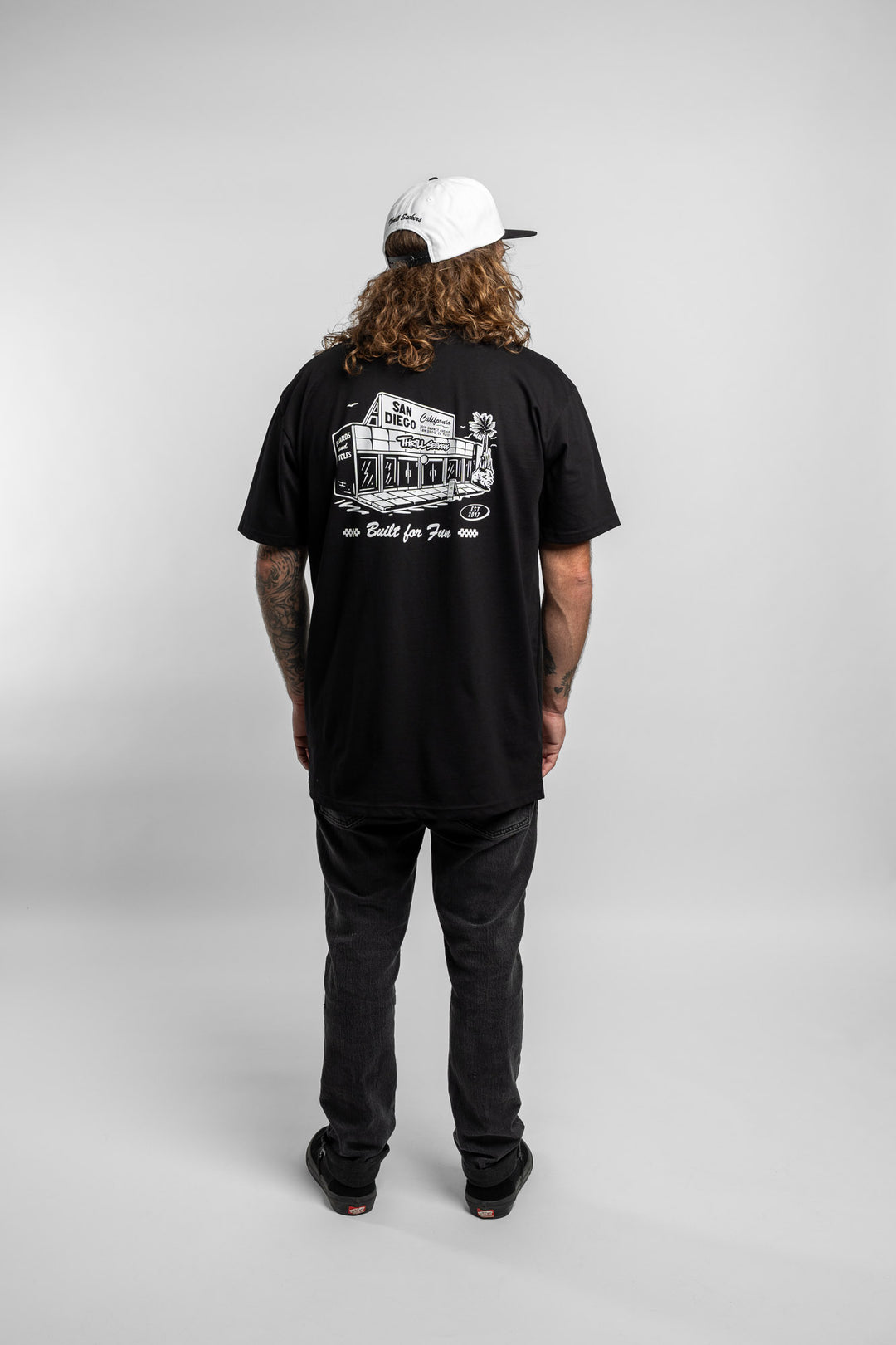 Person wearing black tee with 'Thrill Seekers' shop logo