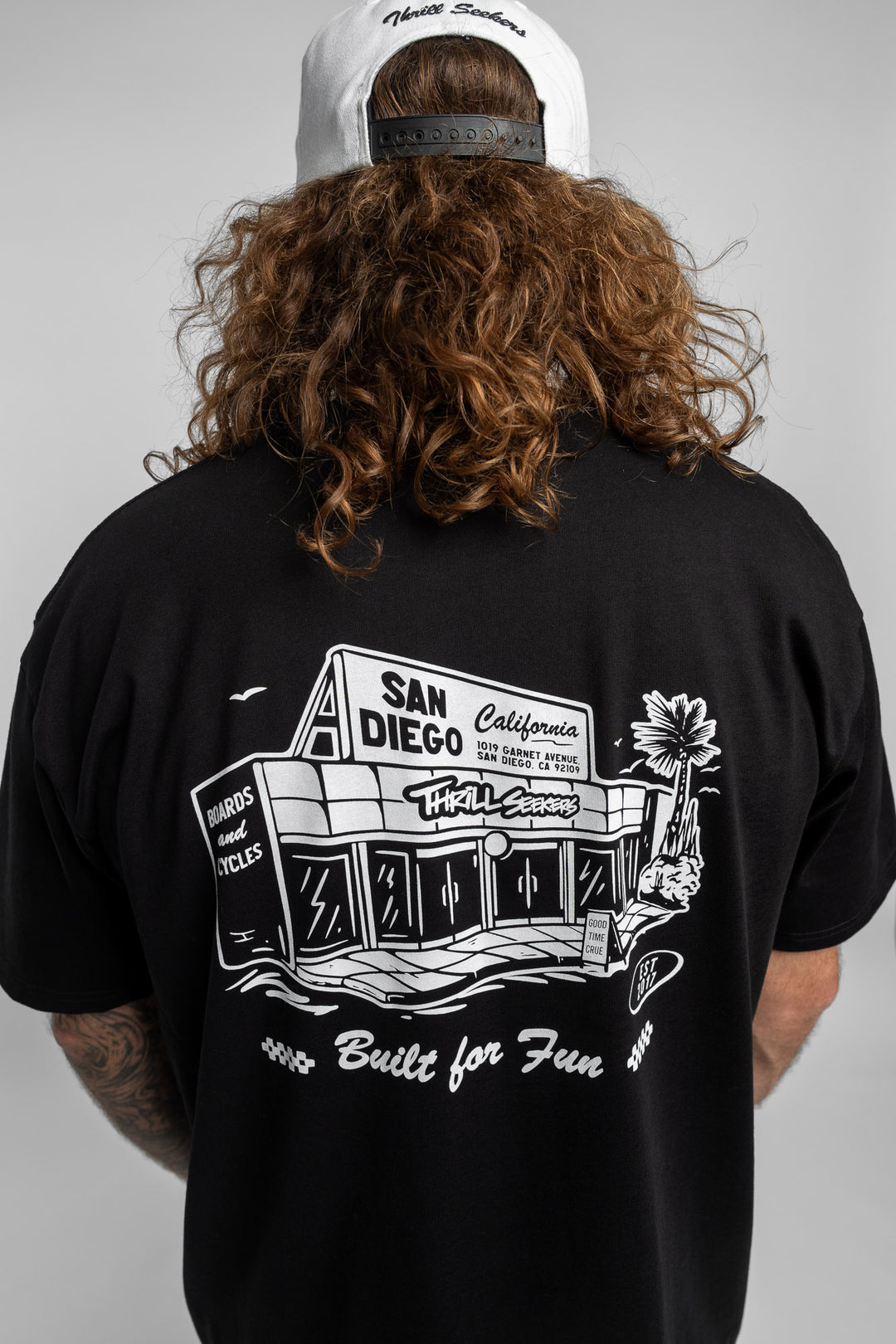 Person wearing black tee with 'Thrill Seekers' shop logo