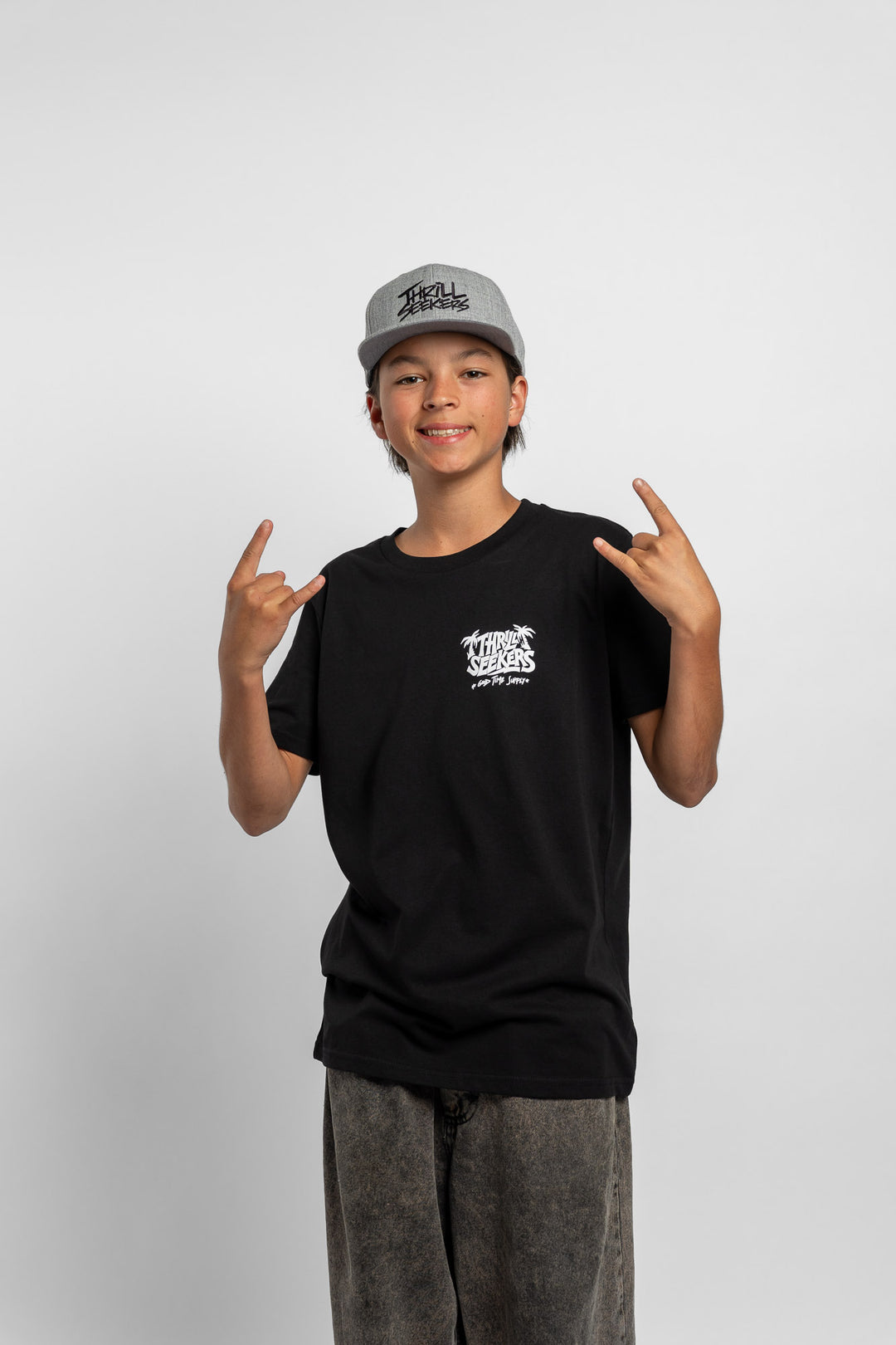 Kid wearing black tee with 'Thrill Seekers' good time supply logo in white