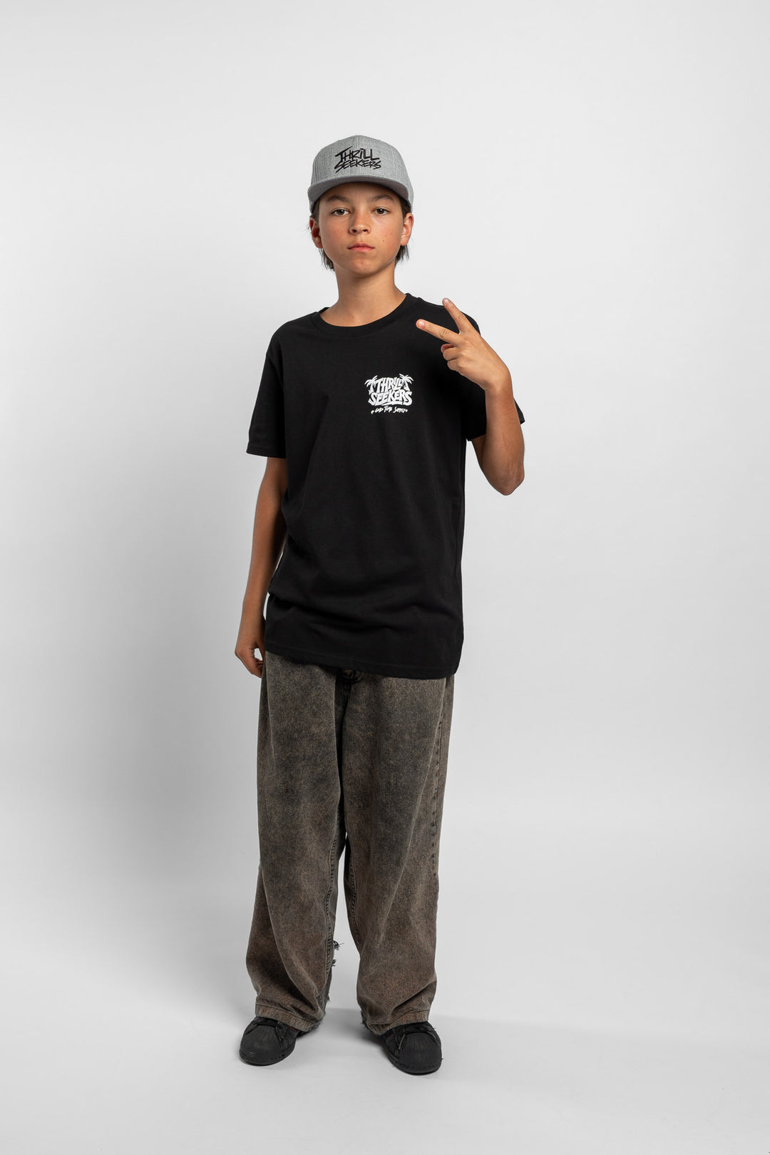 Kid wearing black tee with 'Thrill Seekers' good time supply logo in white