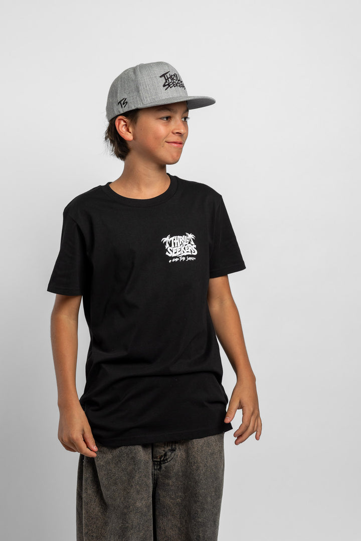 Kid wearing black tee with 'Thrill Seekers' good time supply logo in white