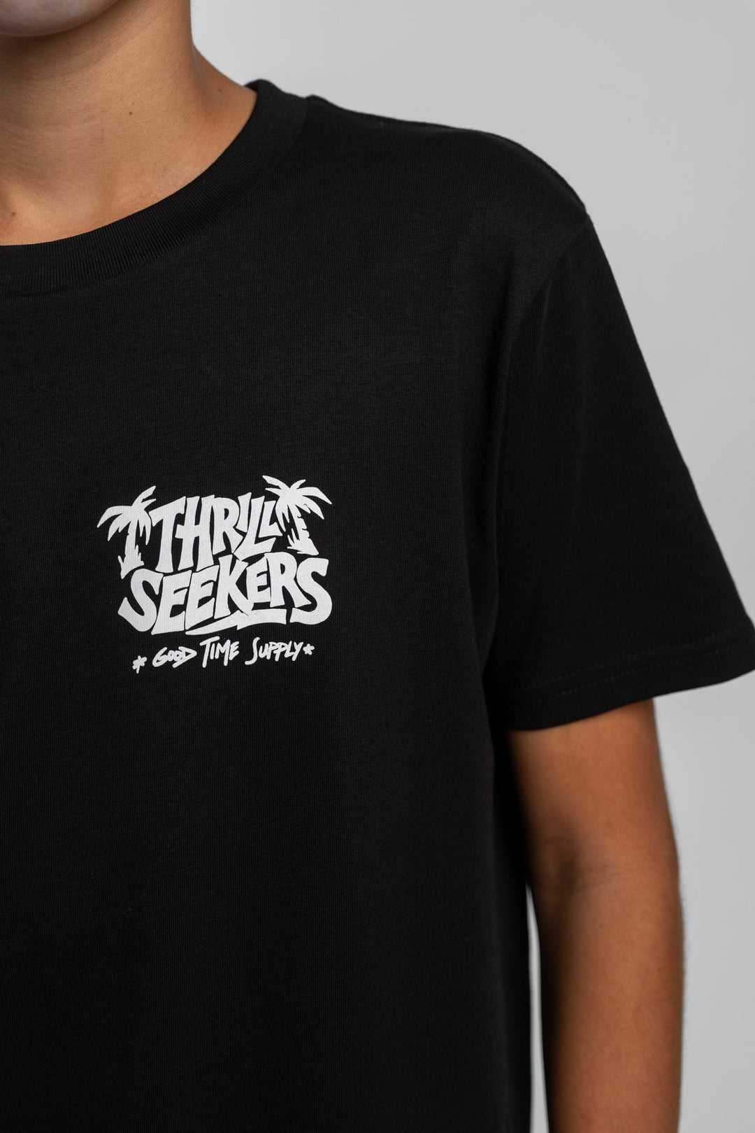 Kid wearing black tee with 'Thrill Seekers' good time supply logo in white