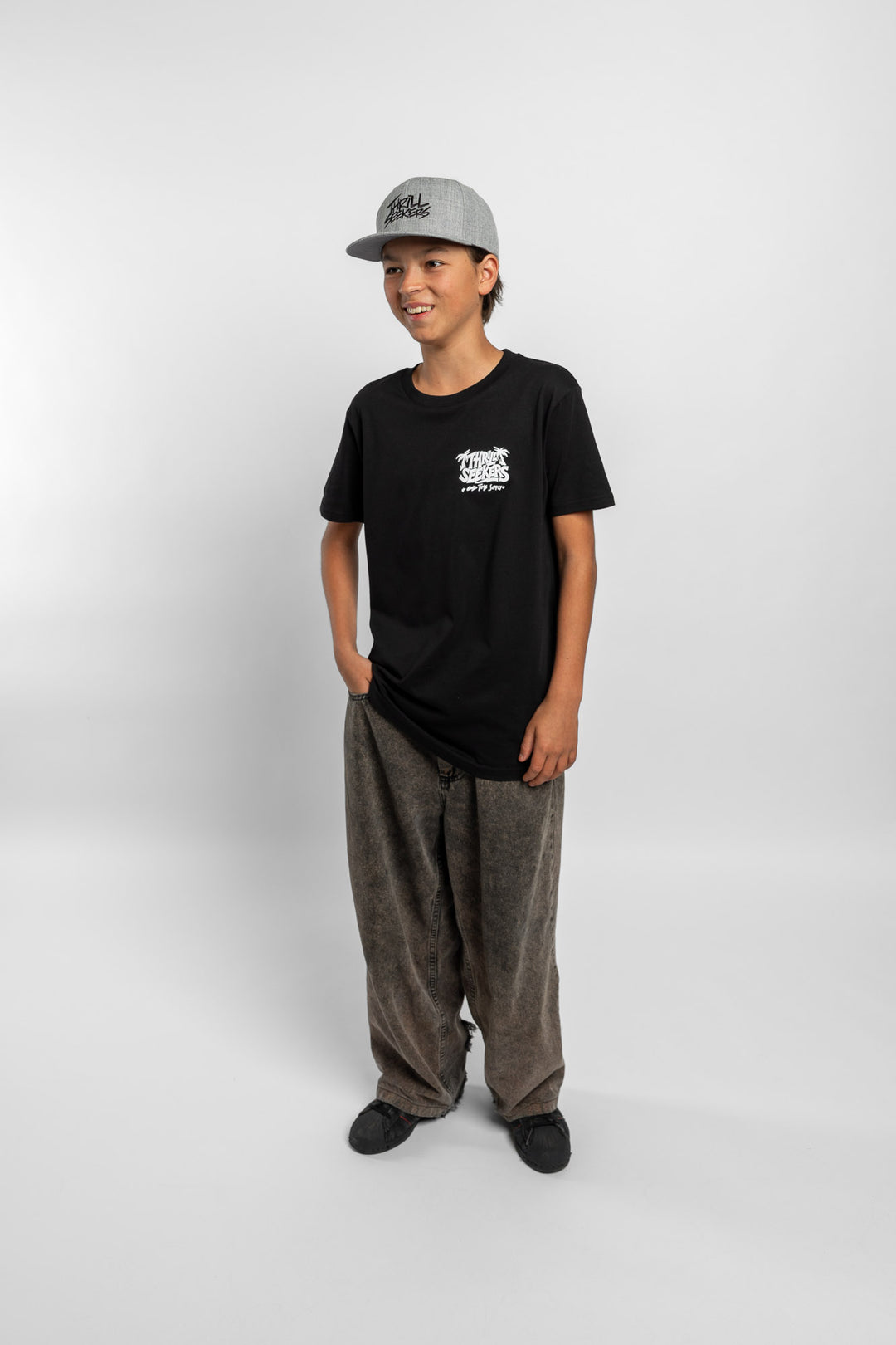 Kid wearing black tee with 'Thrill Seekers' good time supply logo in white