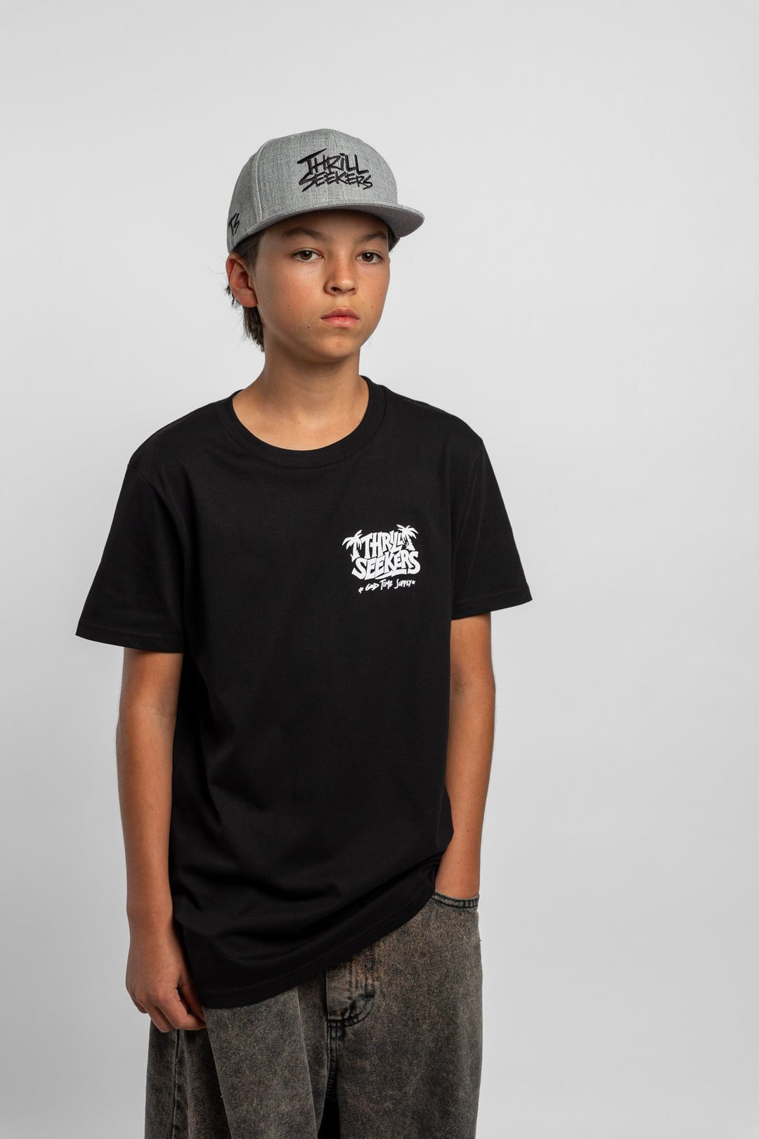 Kid wearing black tee with 'Thrill Seekers' good time supply logo in white