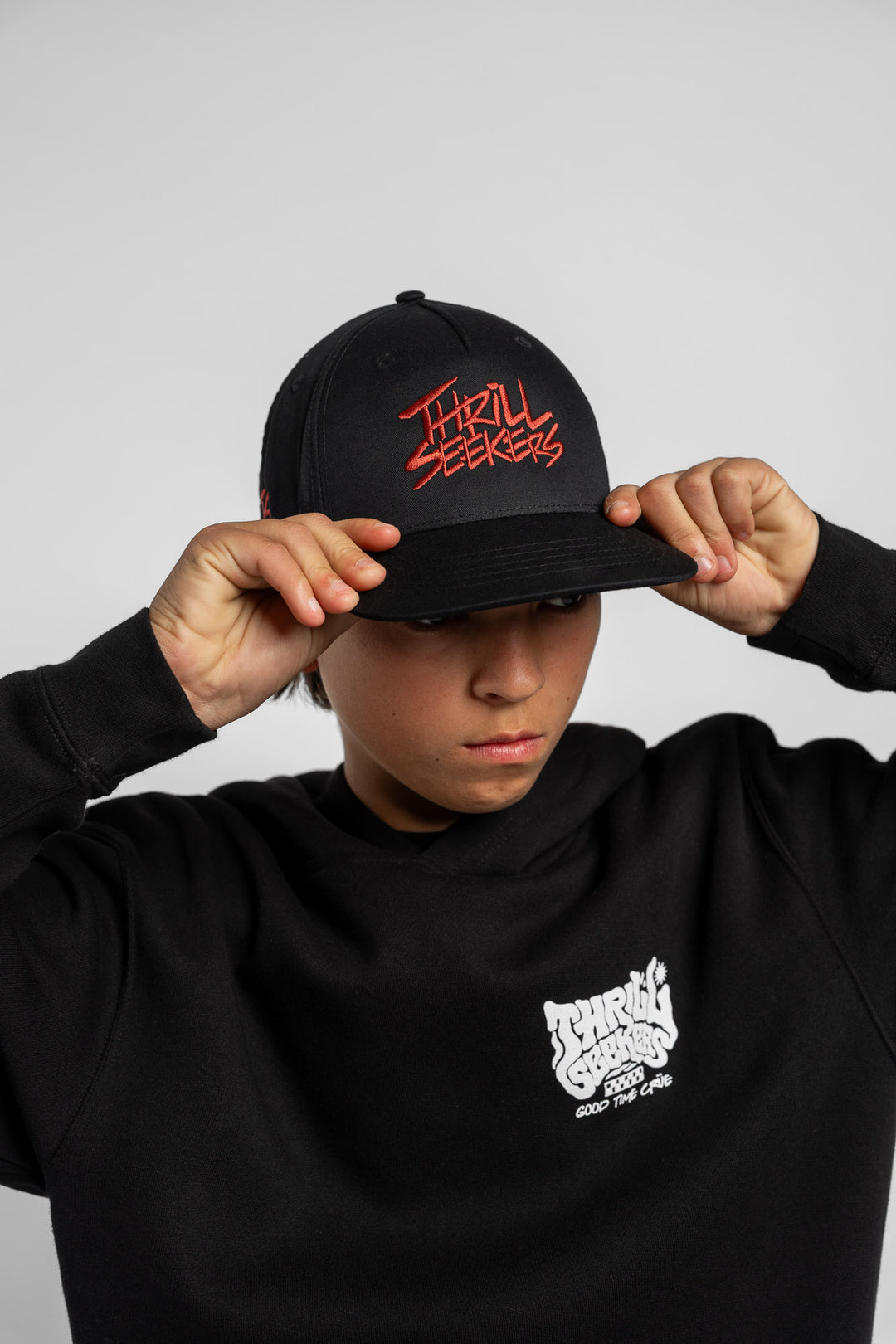 Black cap with cardinal red 'Thrill Seekers' text on a white background