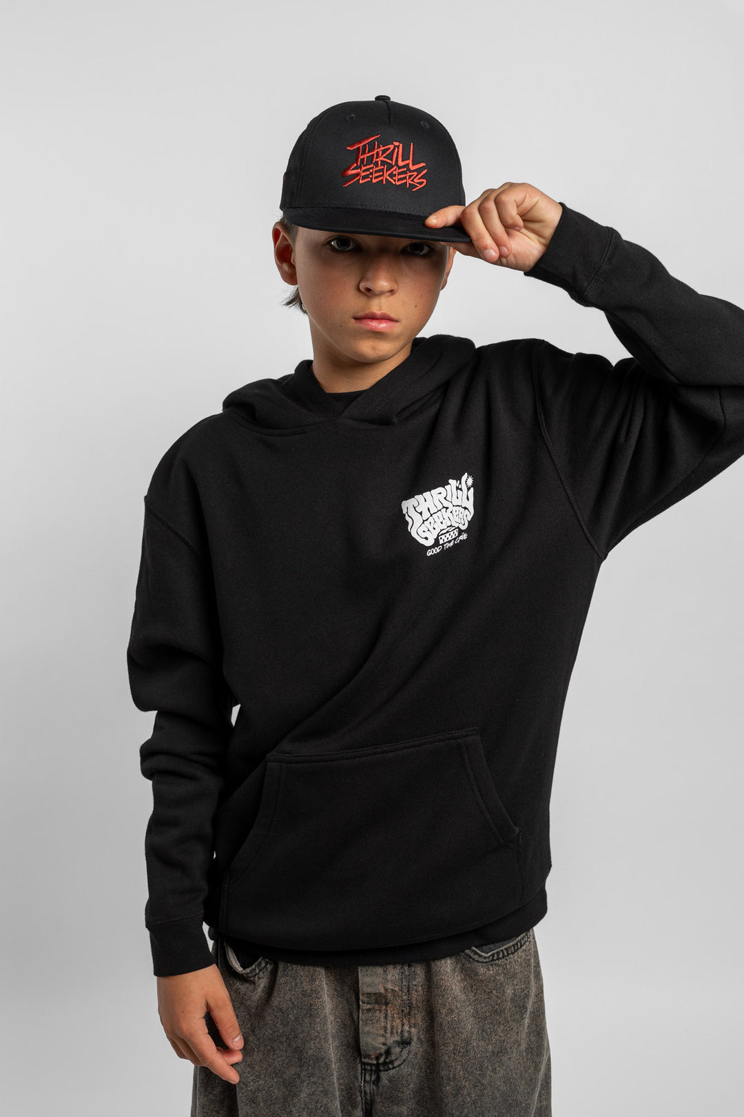 Kid wearing black hoodie with 'Thrill Seekers' smokin' logo in black