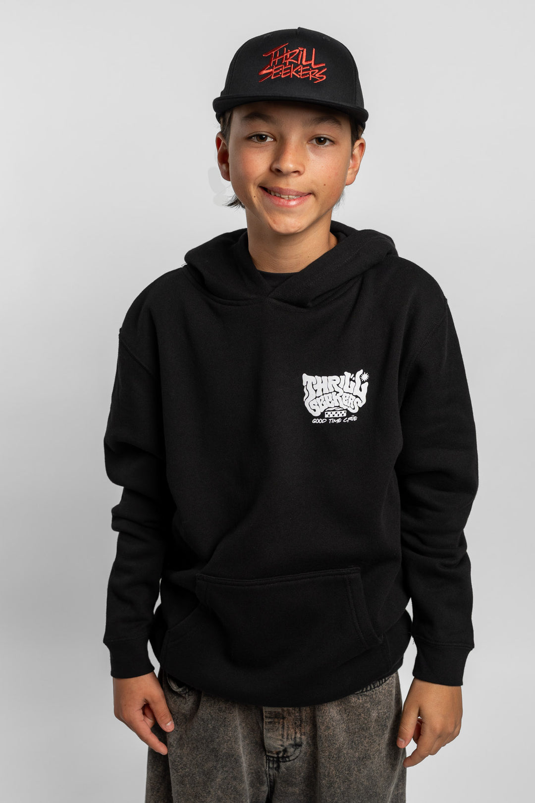Kid wearing black hoodie with 'Thrill Seekers' smokin' logo in black