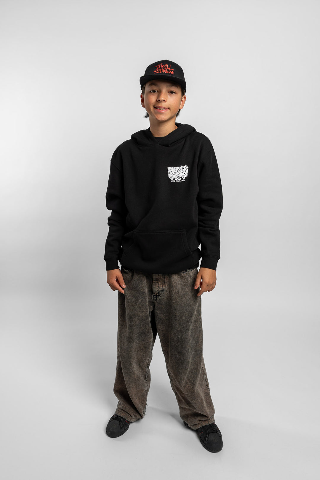 Kid wearing black hoodie with 'Thrill Seekers' smokin' logo in black