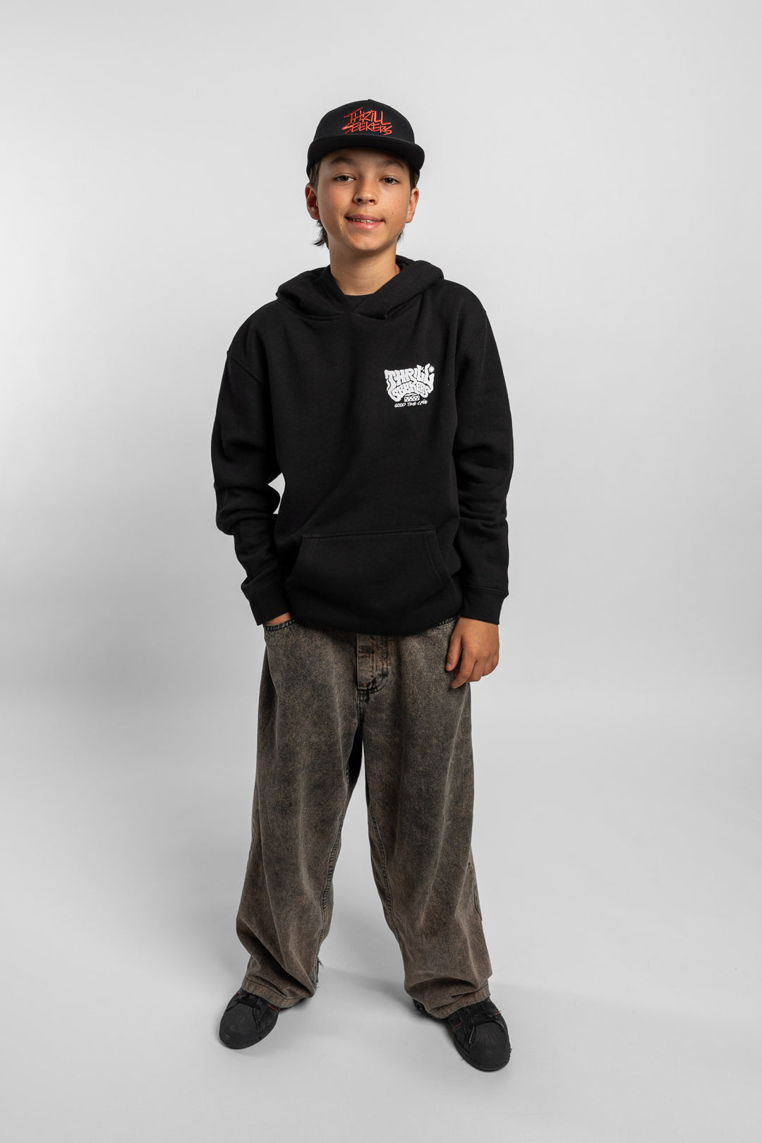 Kid wearing black hoodie with 'Thrill Seekers' smokin' logo in black
