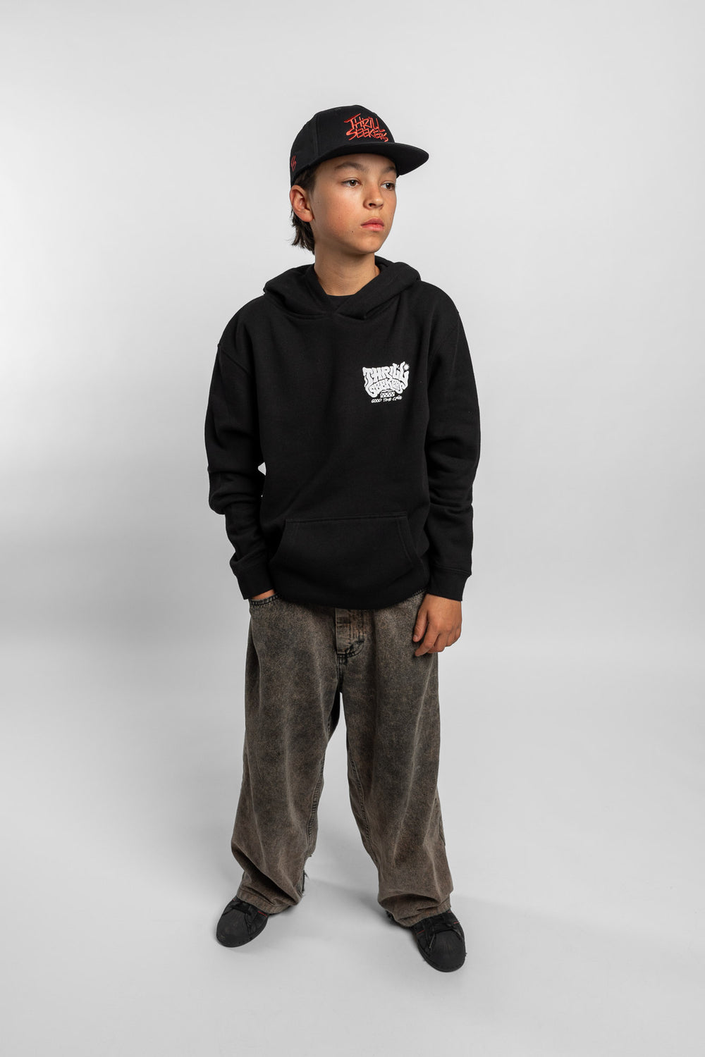 Kid wearing black hoodie with 'Thrill Seekers' smokin' logo in black