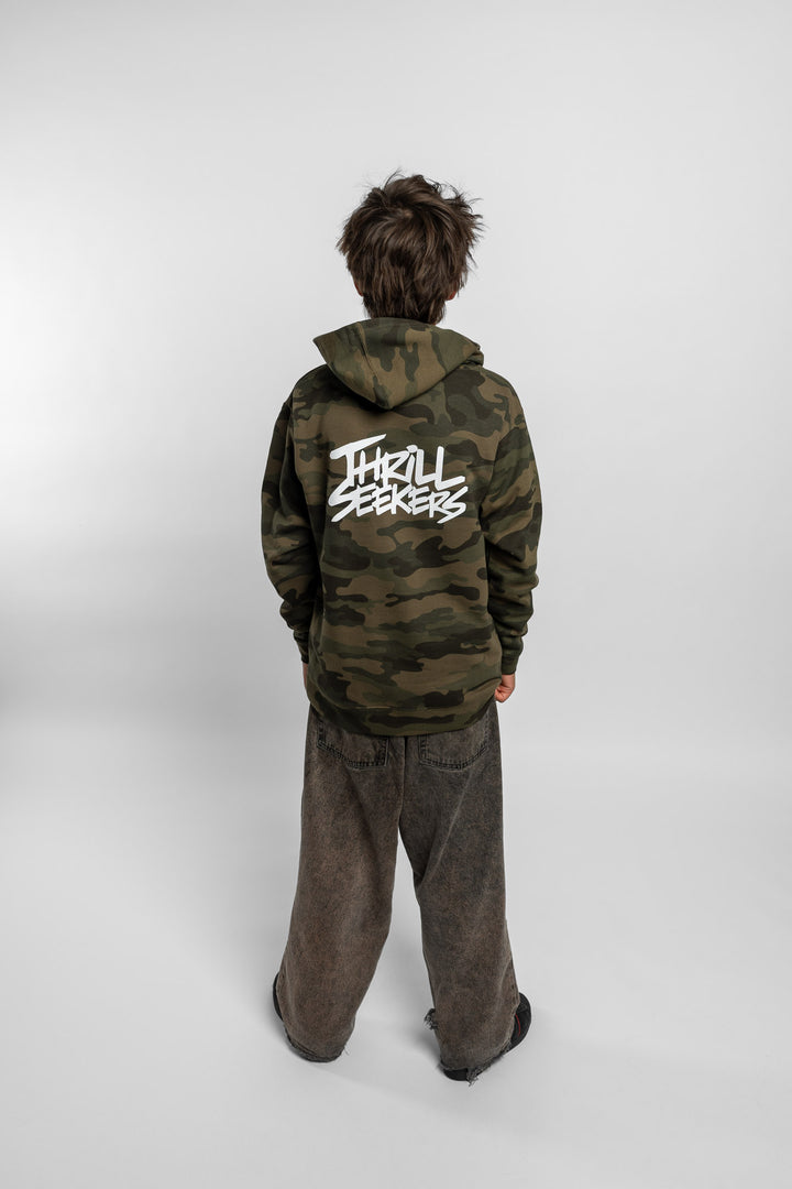 Kid wearing a camo hoodie with 'Thrill Seekers' logo in white