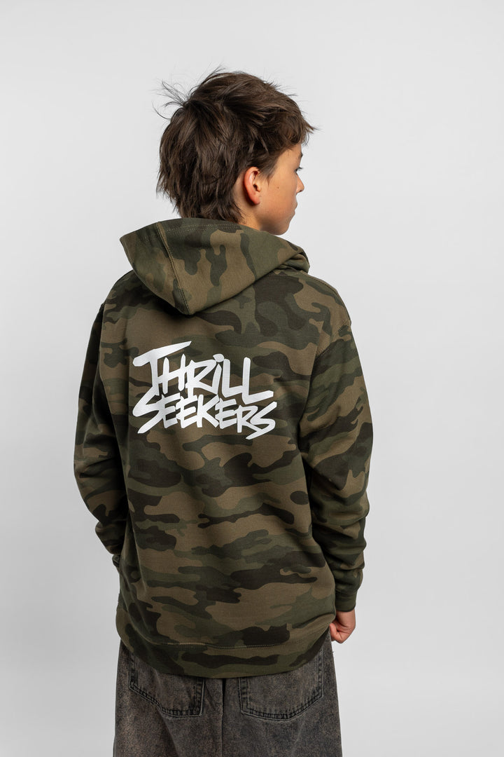 Kid wearing a camo hoodie with 'Thrill Seekers' logo in white