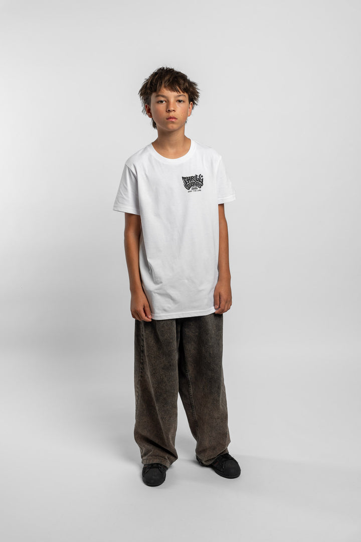 Kid wearing a white tee with 'Thrill Seekers' smokin logo in black
