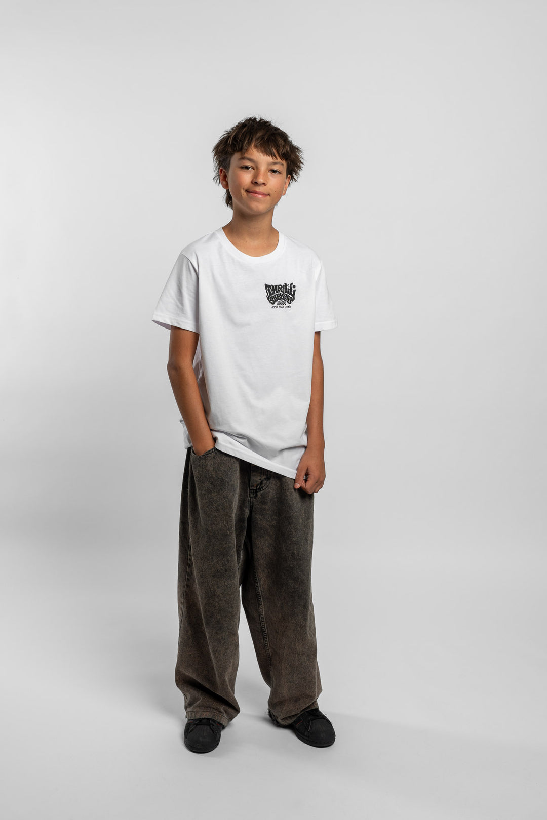 Kid wearing a white tee with 'Thrill Seekers' smokin logo in black