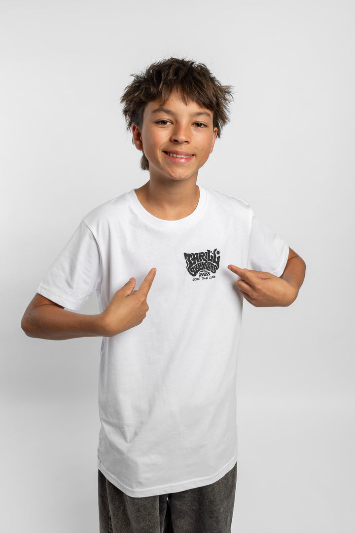 Kid wearing a white tee with 'Thrill Seekers' smokin logo in black