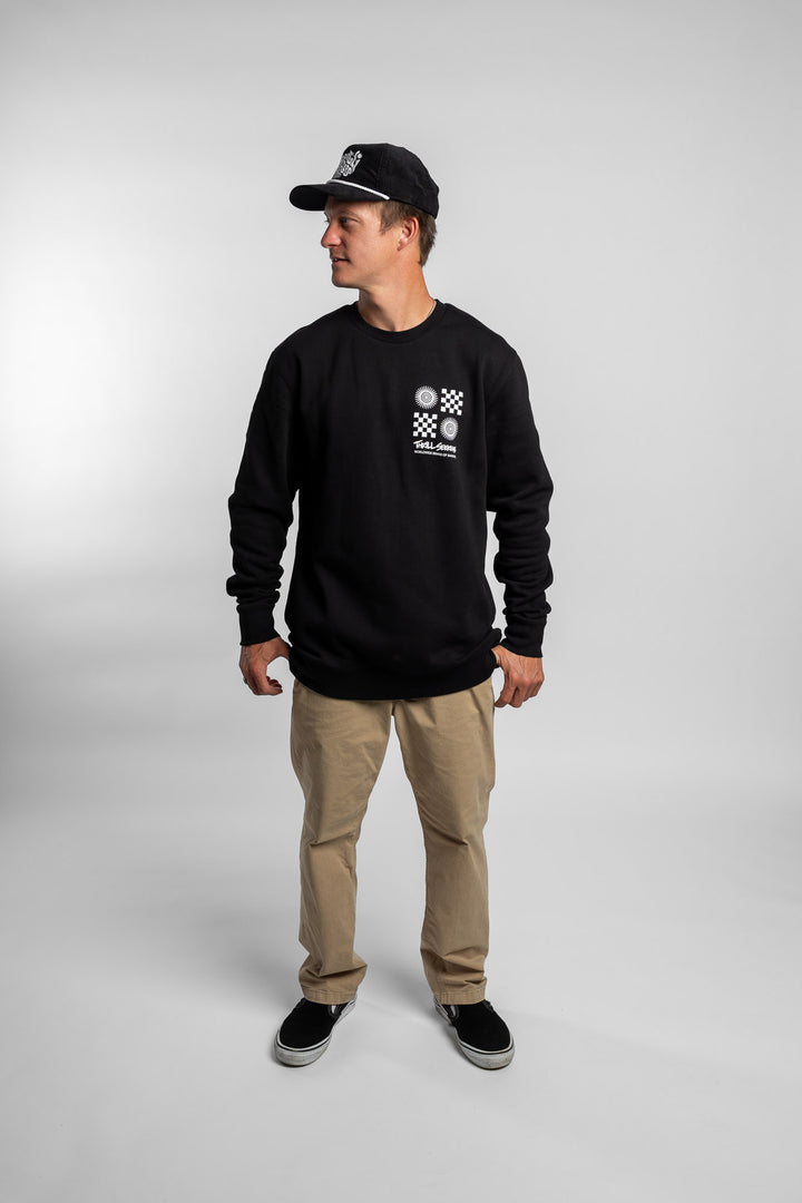 Person wearing a black crewneck with a 'Thrill Seekers' tile logo