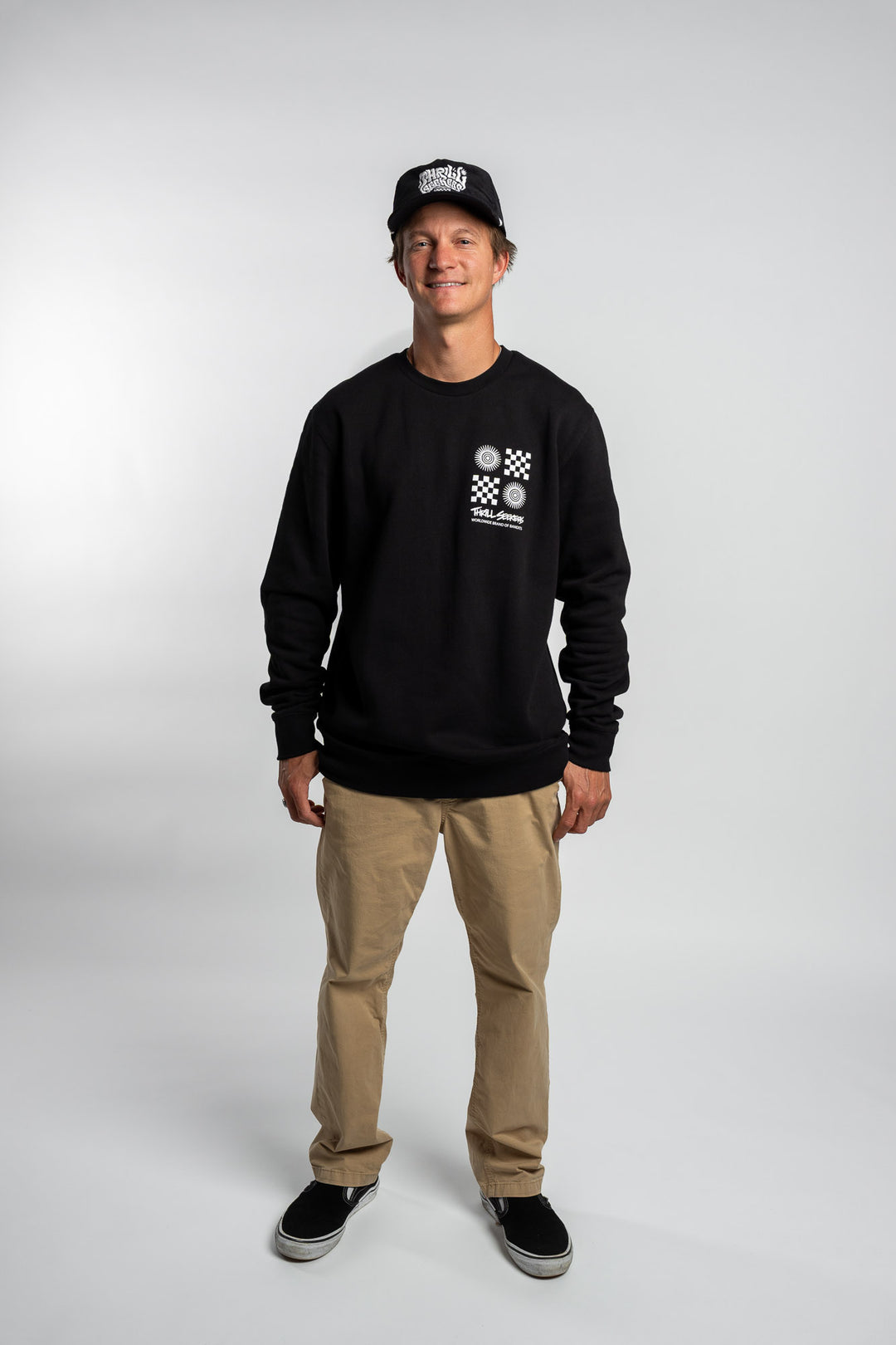 Person wearing a black crewneck with a 'Thrill Seekers' tile logo