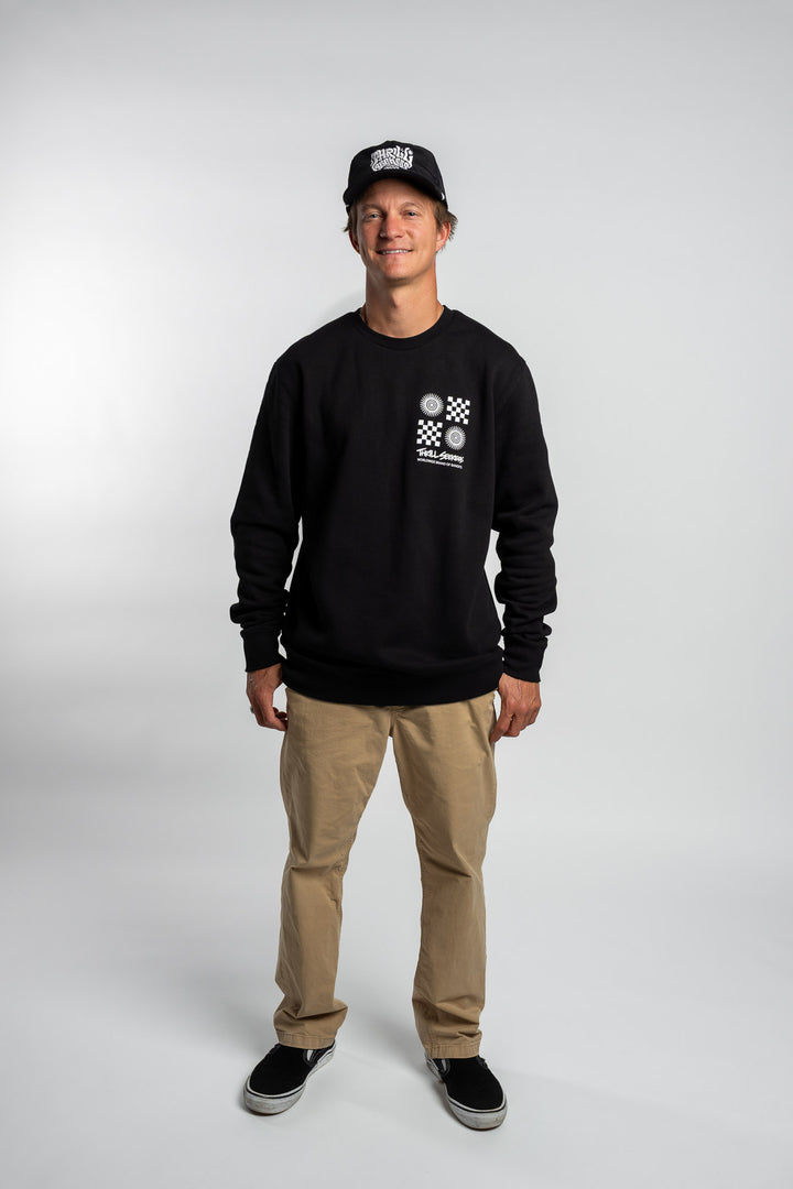 Person wearing a black crewneck with a 'Thrill Seekers' tile logo