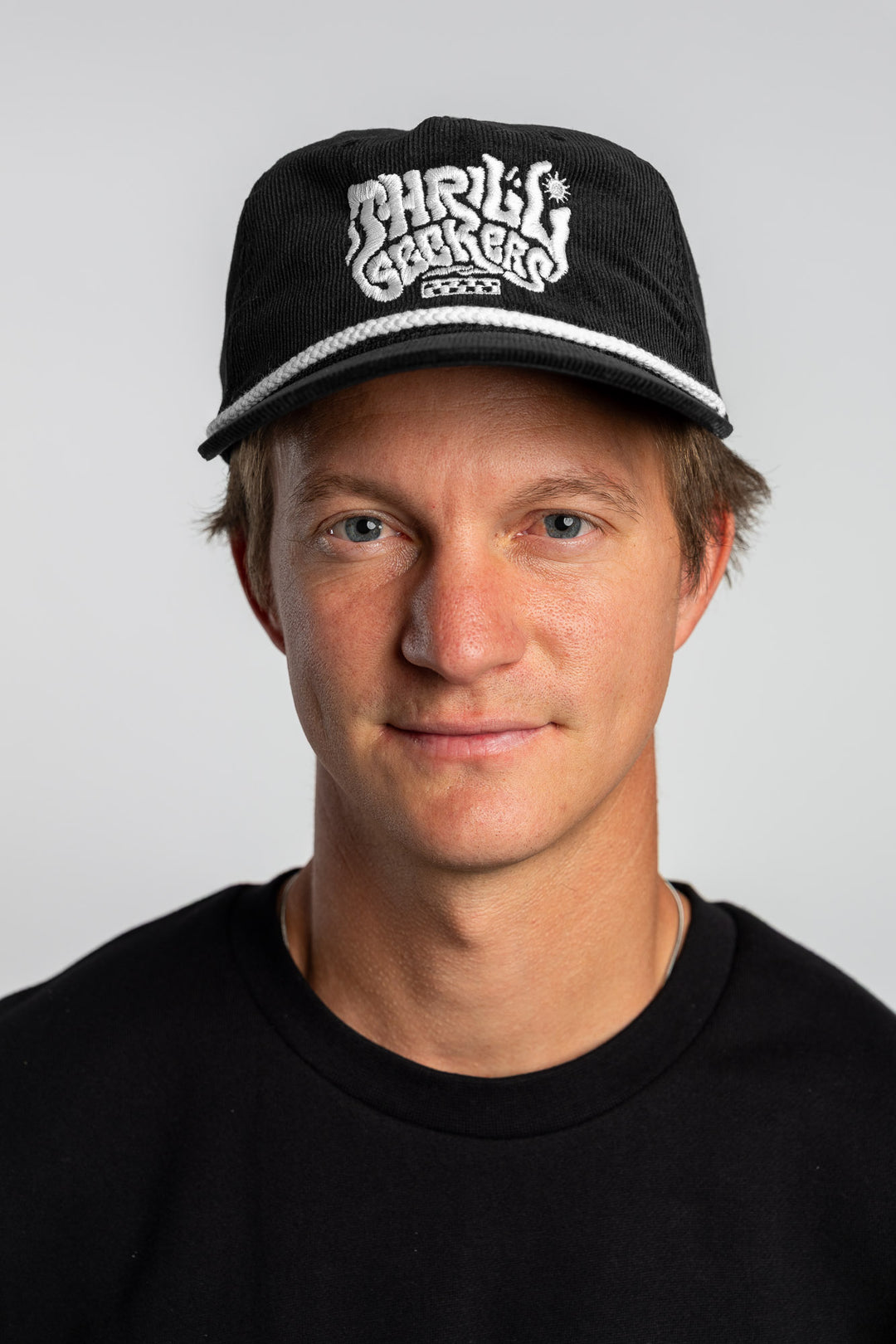 Person wearing a black corduroy cap with 'Thrill Seekers' logo on a white background
