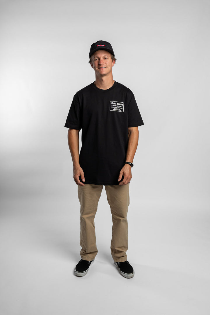 Person wearing black tee with 'Thrill Seekers' workman logo in white