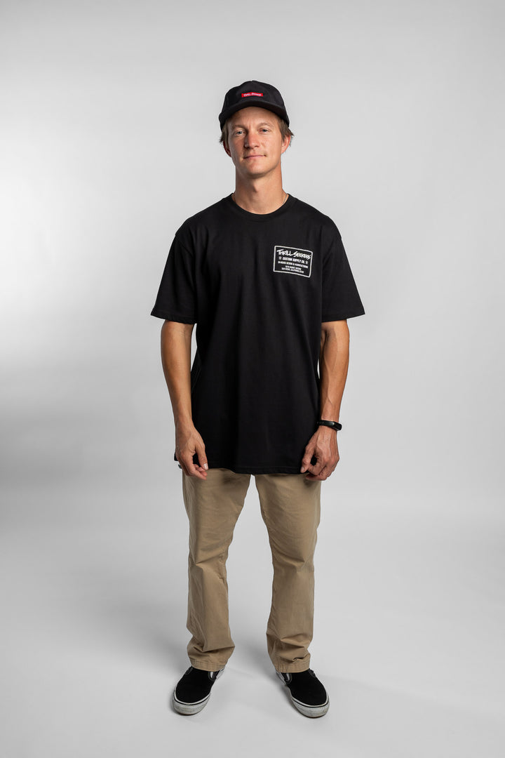 Person wearing black tee with 'Thrill Seekers' workman logo in white