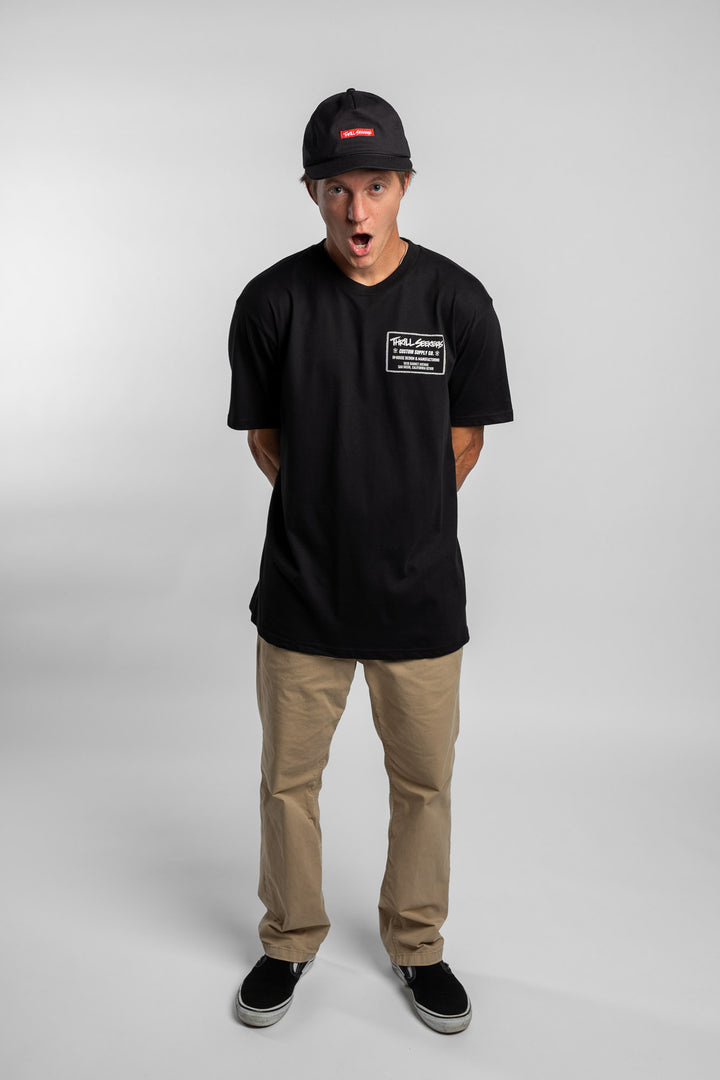 Person wearing black tee with 'Thrill Seekers' workman logo in white