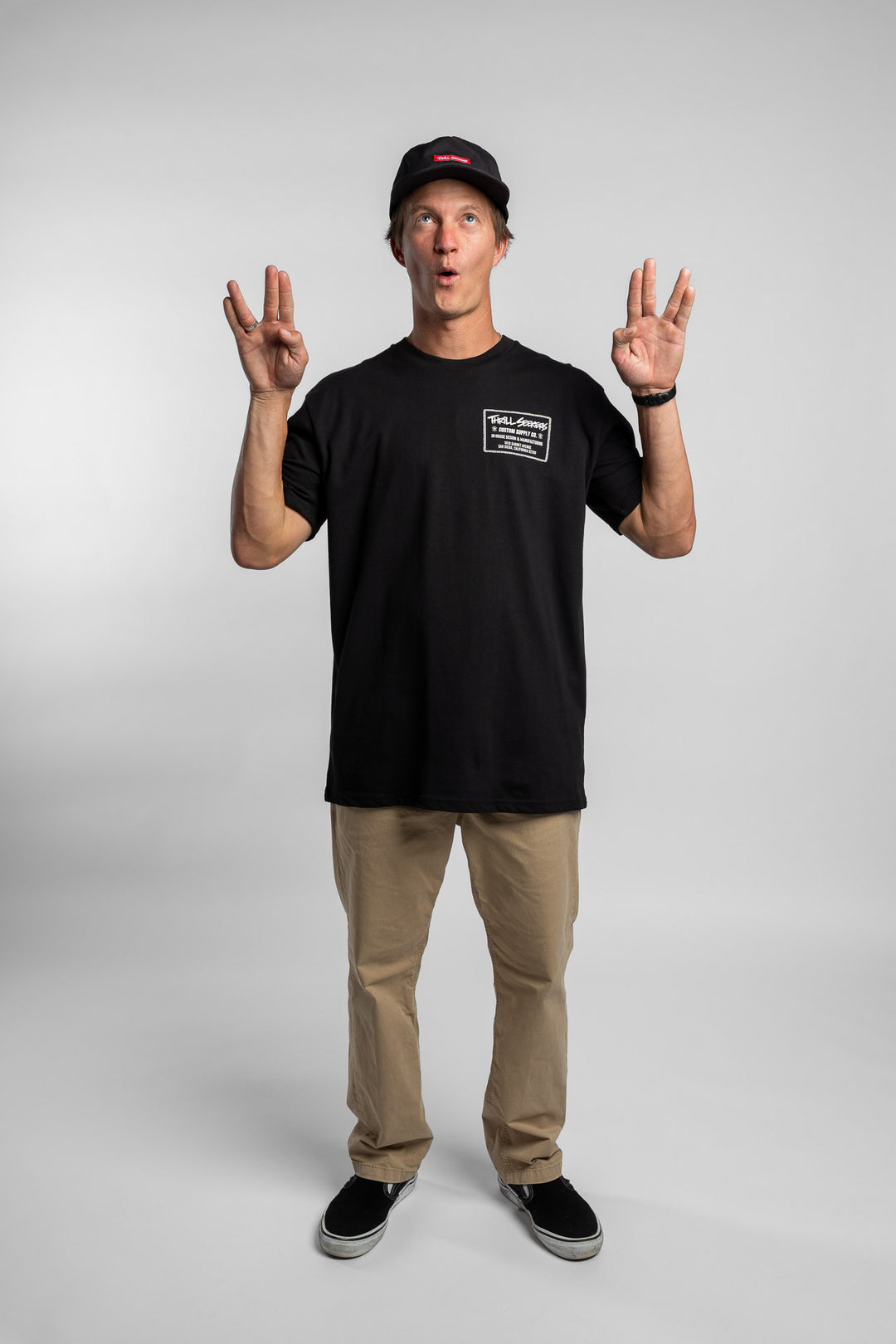 Person wearing black tee with 'Thrill Seekers' workman logo in white