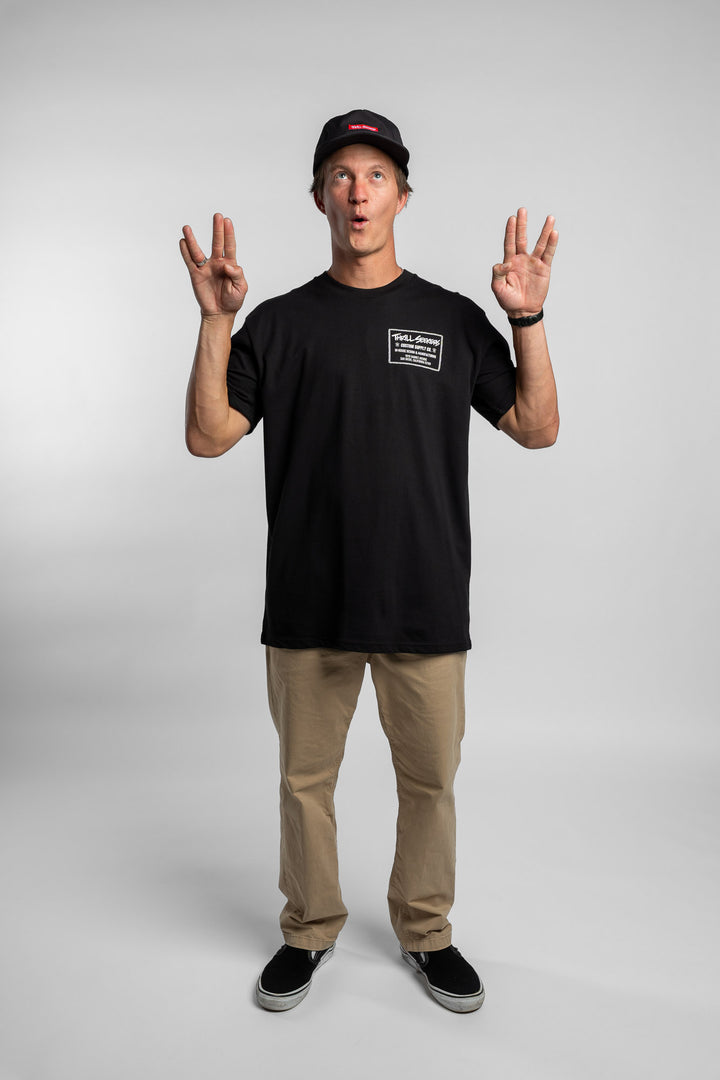 Person wearing black tee with 'Thrill Seekers' workman logo in white