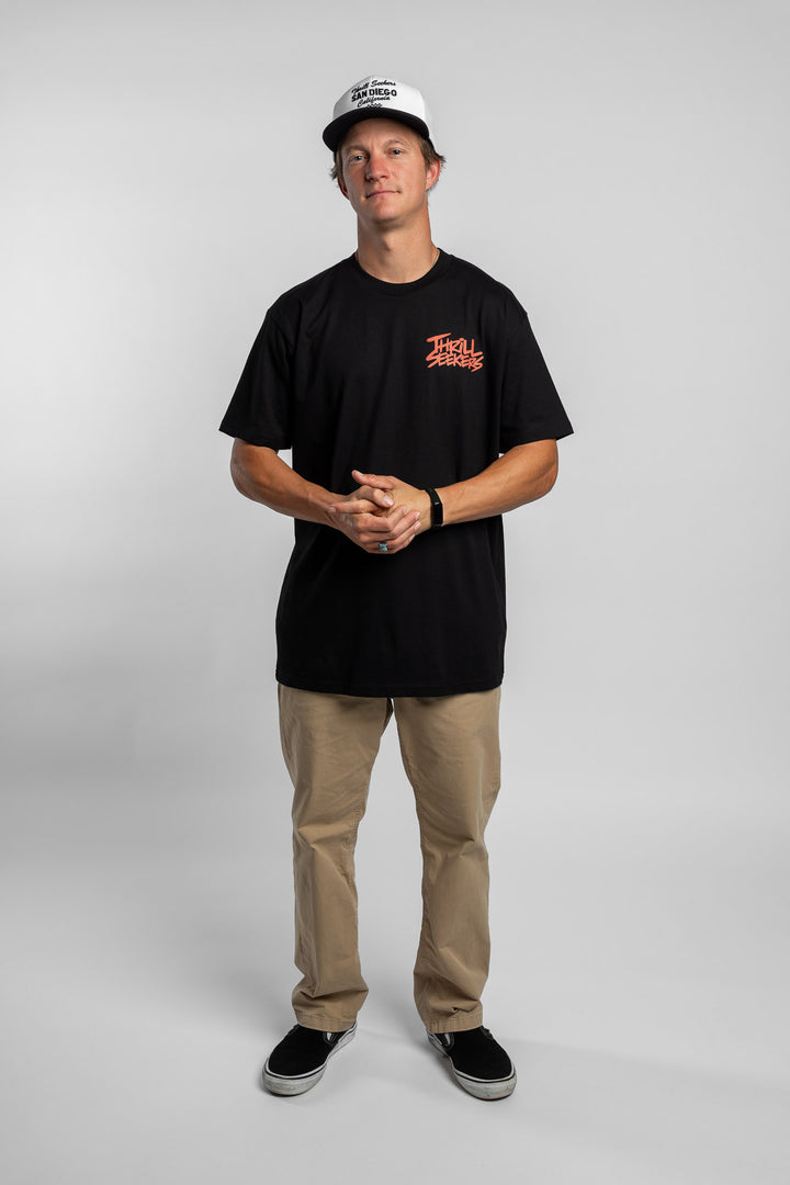 Person wearing a black tee with a 'Thrill Seekers' logo in cardinal red