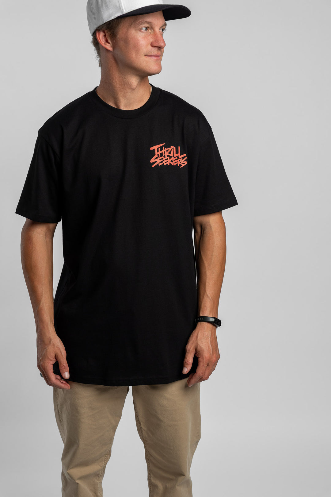 Person wearing a black tee with a 'Thrill Seekers' logo in cardinal red