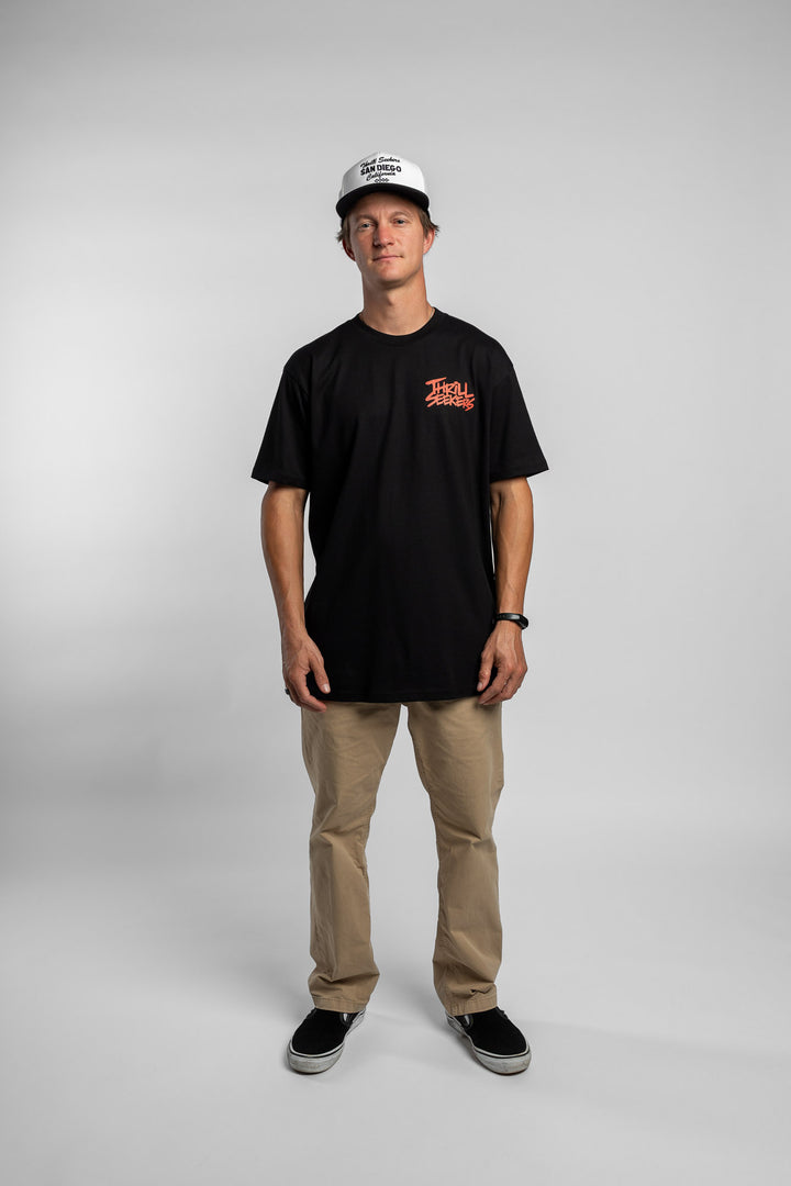 Person wearing a black tee with a 'Thrill Seekers' logo in cardinal red