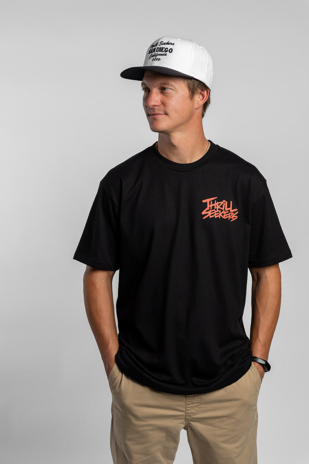 Person wearing a black tee with a 'Thrill Seekers' logo in cardinal red