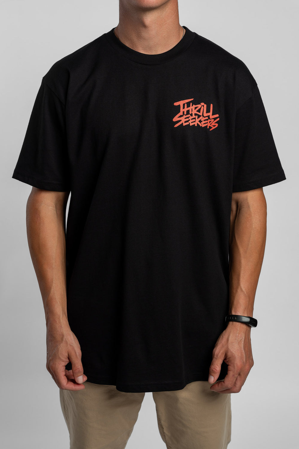 Person wearing a black tee with a 'Thrill Seekers' logo in cardinal red