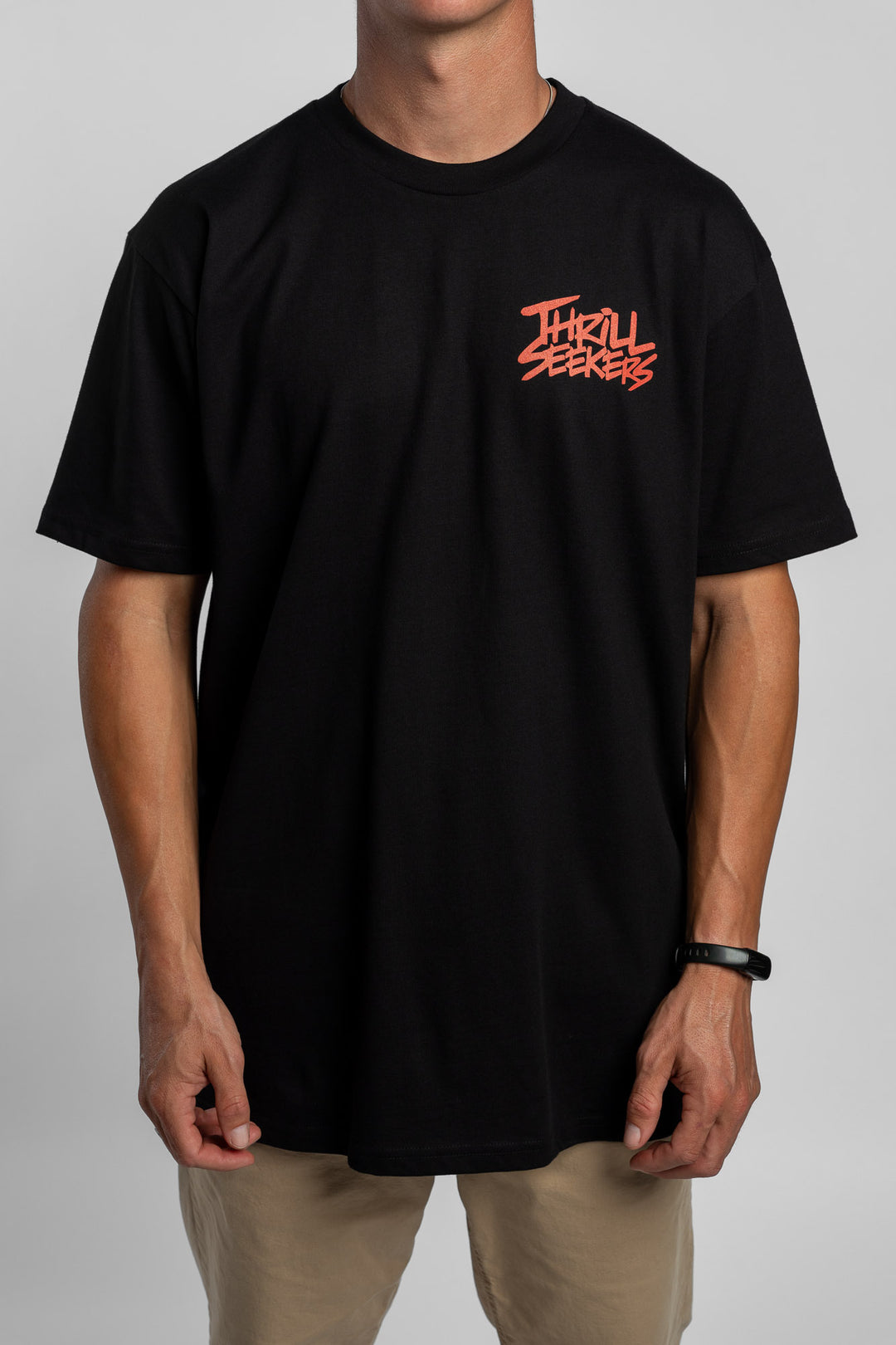 Person wearing a black tee with a 'Thrill Seekers' logo in cardinal red