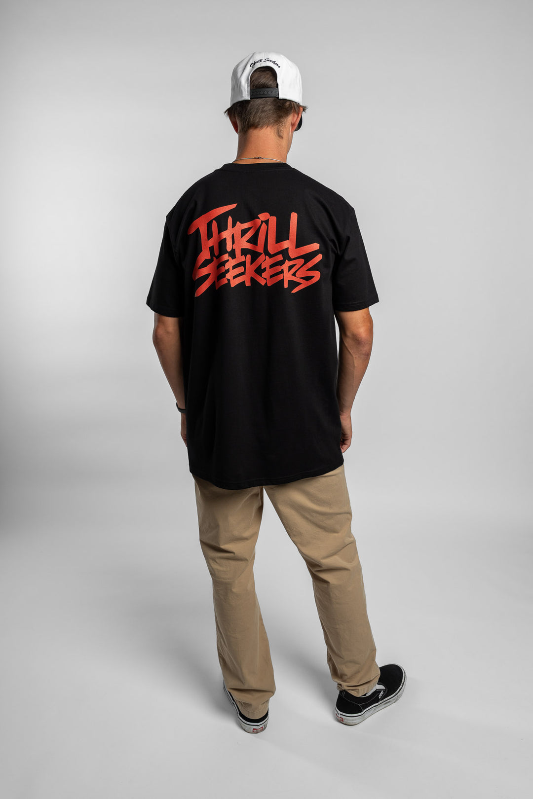 Person wearing a black tee with a 'Thrill Seekers' logo in cardinal red