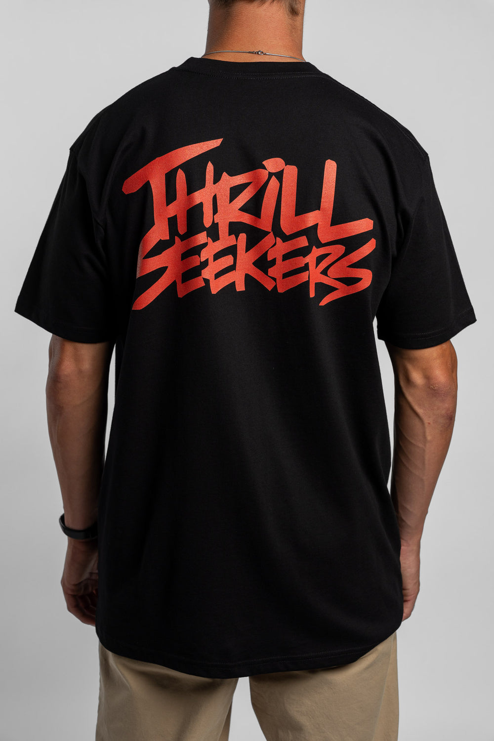 Person wearing a black tee with a 'Thrill Seekers' logo in cardinal red