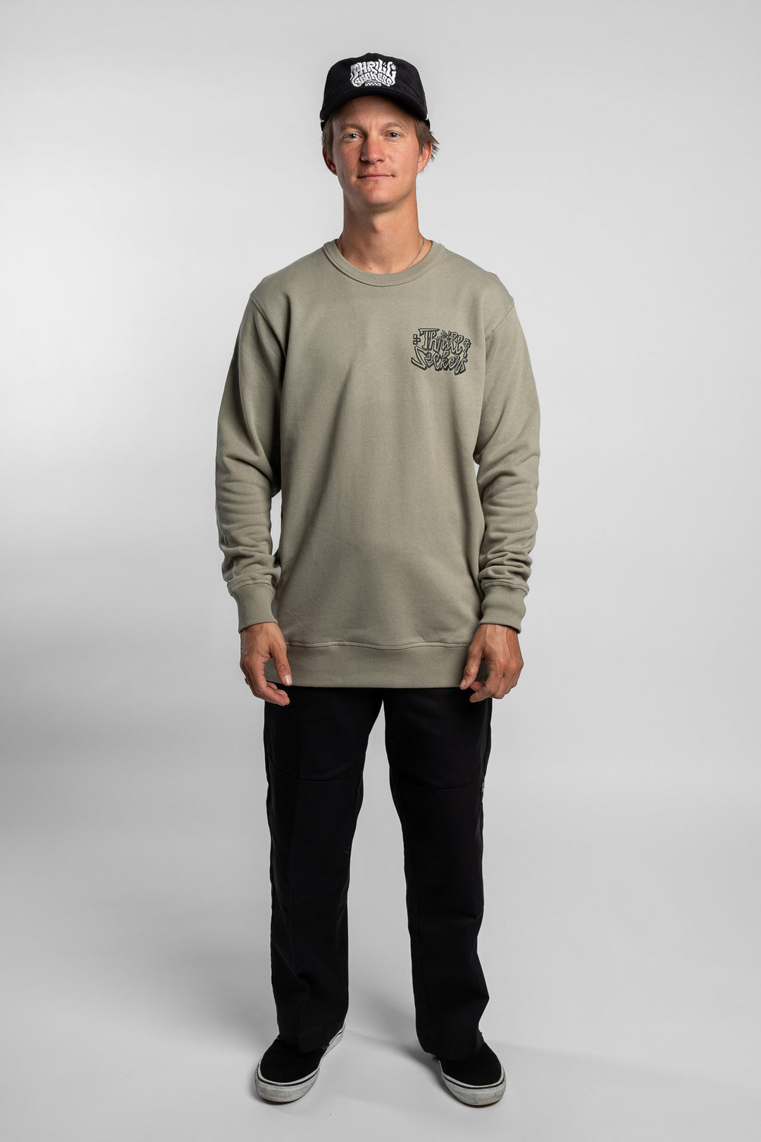 Person wearing eucalyptus crewneck with 'Thrill Seekers' scribe logo