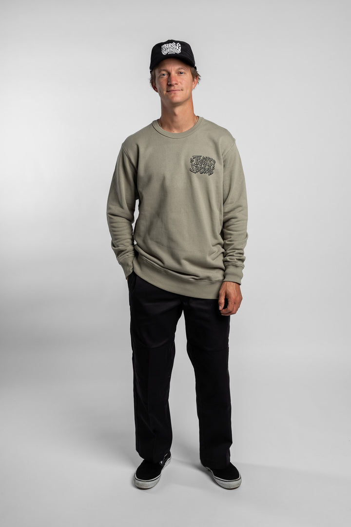 Person wearing eucalyptus crewneck with 'Thrill Seekers' scribe logo