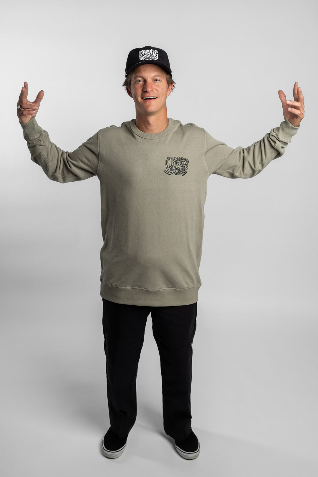 Person wearing eucalyptus crewneck with 'Thrill Seekers' scribe logo