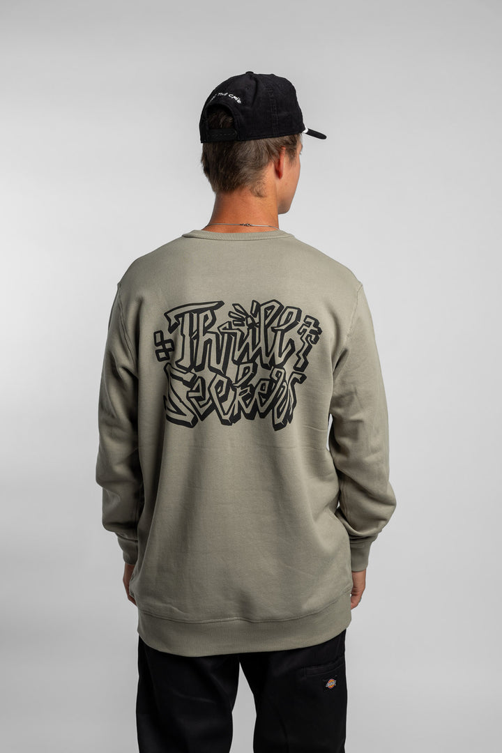 Person wearing eucalyptus crewneck with 'Thrill Seekers' scribe logo