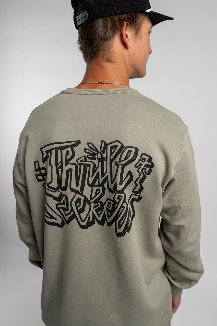 Person wearing eucalyptus crewneck with 'Thrill Seekers' scribe logo
