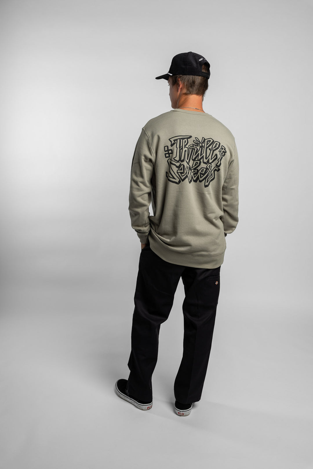 Person wearing eucalyptus crewneck with 'Thrill Seekers' scribe logo