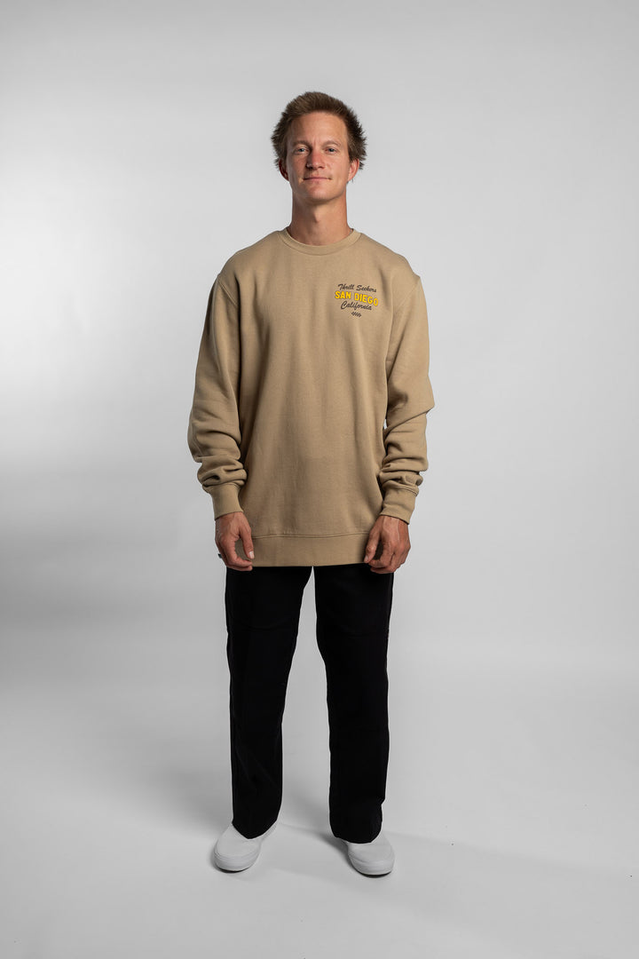 Person wearing sand crewneck with 'Thrill Seekers' shop logo