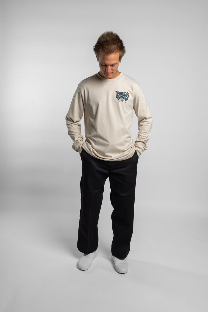 Person wearing a bone colored long-sleeve shirt with a 'Thrill Seekers' logo