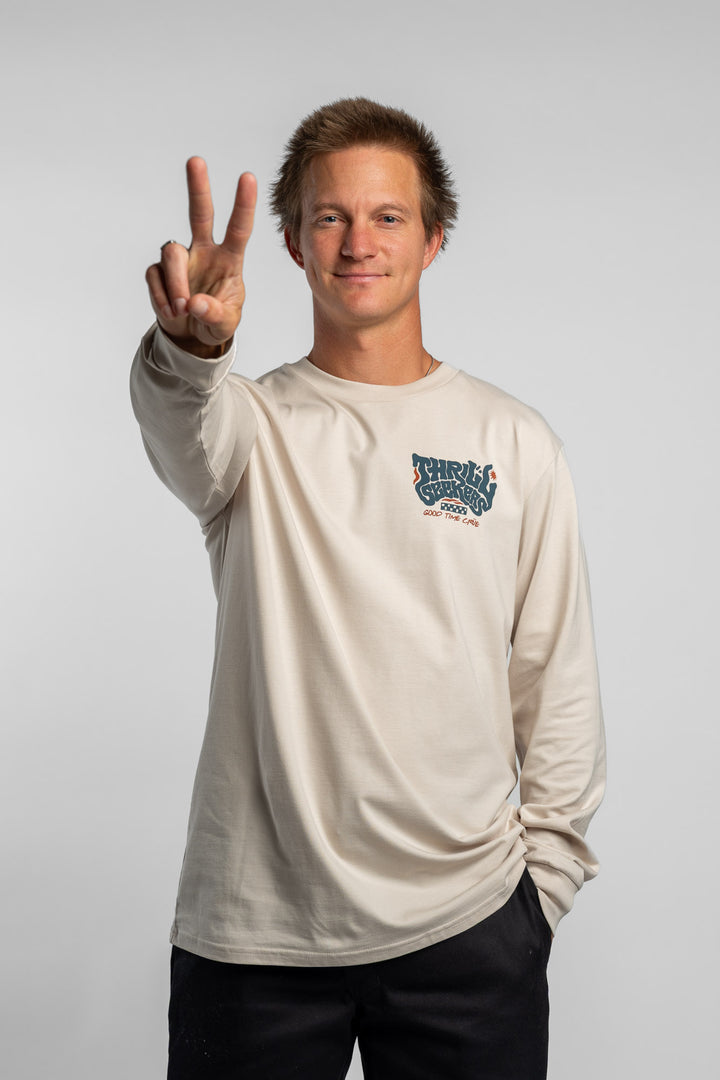 Person wearing a bone colored long-sleeve shirt with a 'Thrill Seekers' logo