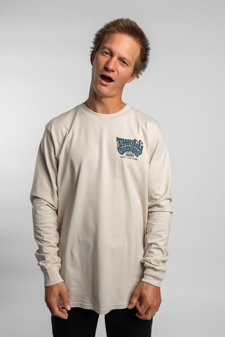 Person wearing a bone colored long-sleeve shirt with a 'Thrill Seekers' logo