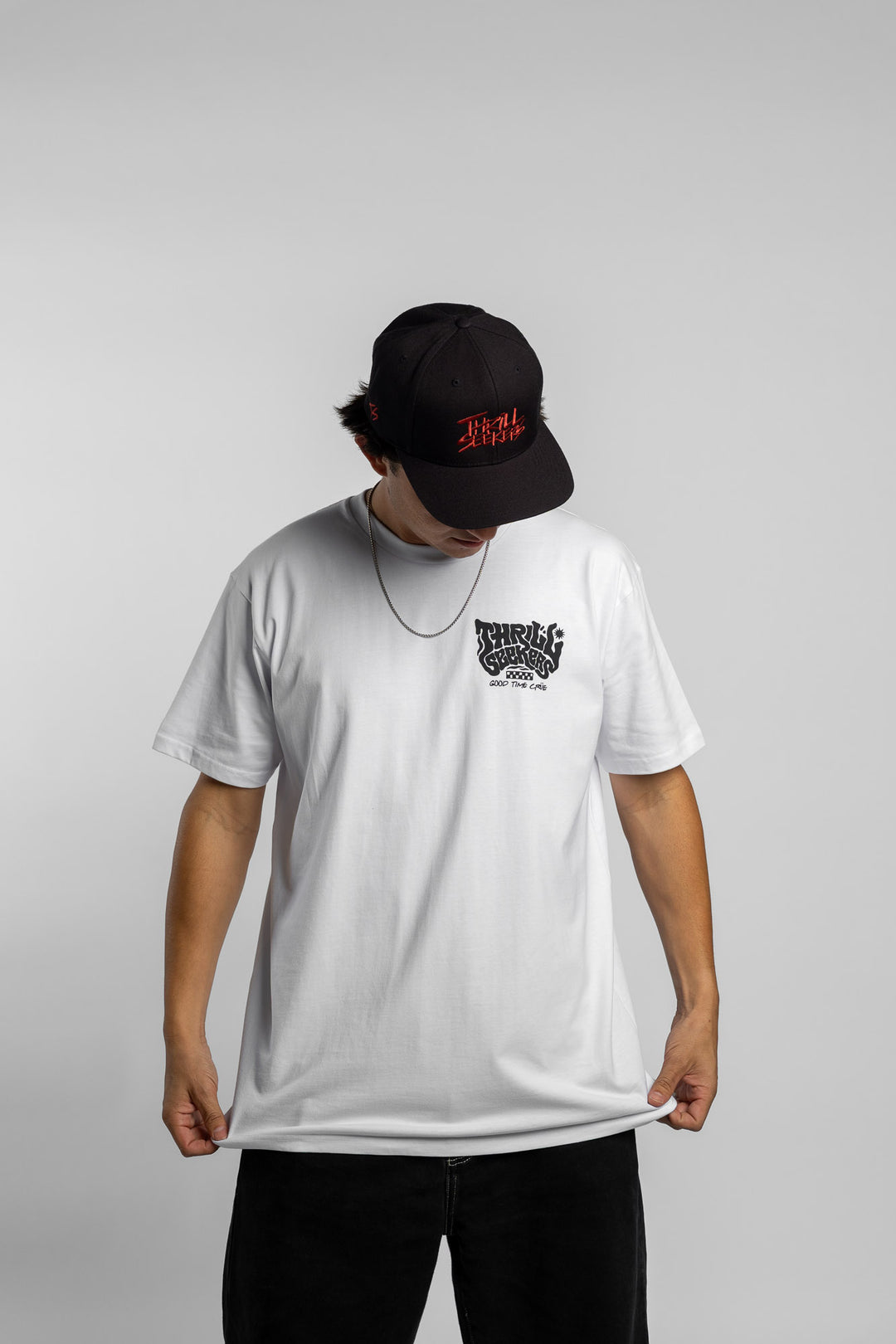Person wearing a white t-shirt with black 'Thrill Seekers' smokin' logo