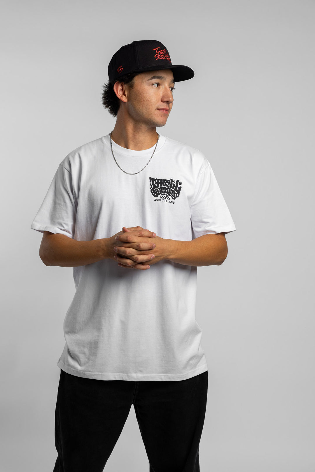 Person wearing a white t-shirt with black 'Thrill Seekers' smokin' logo