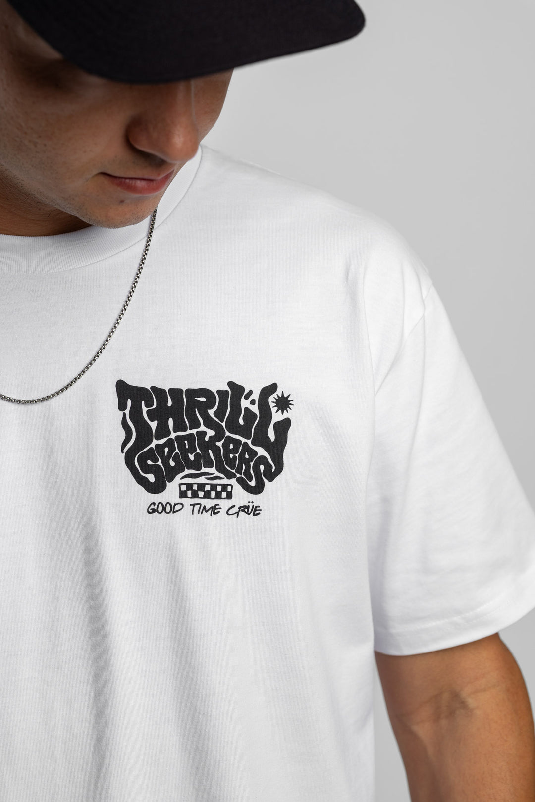 Person wearing a white t-shirt with black 'Thrill Seekers' smokin' logo