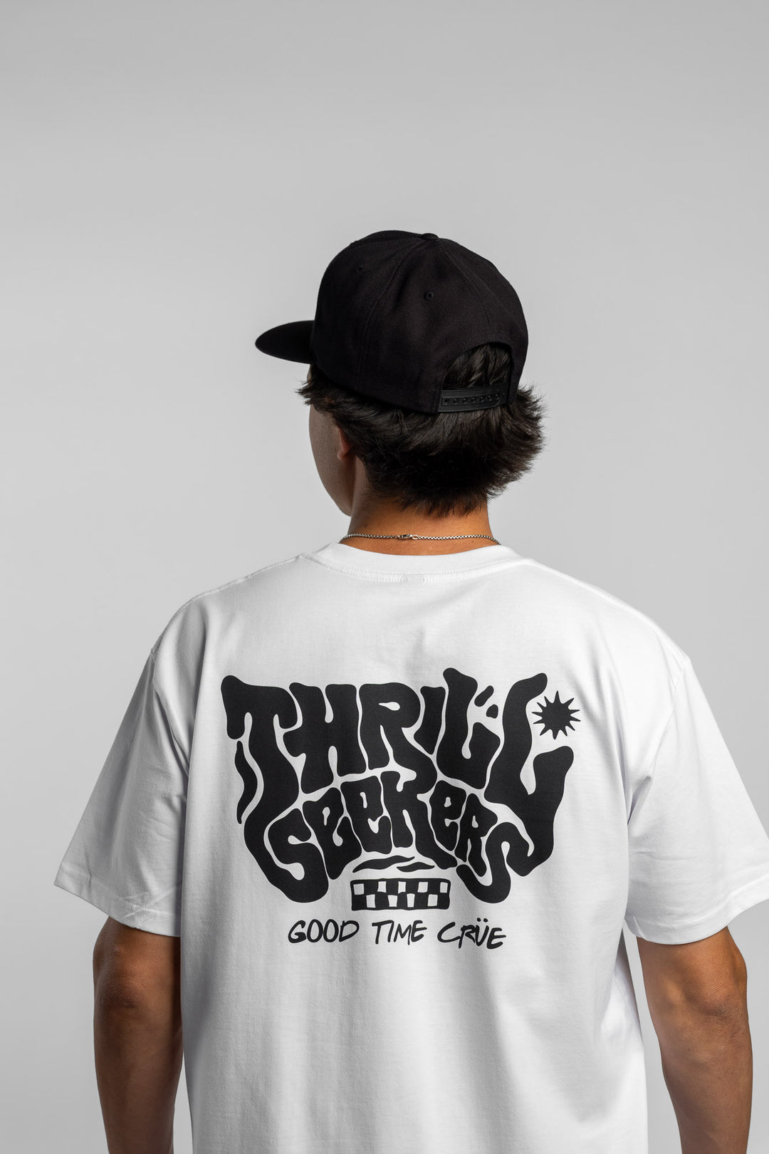 Person wearing a white t-shirt with black 'Thrill Seekers' smokin' logo